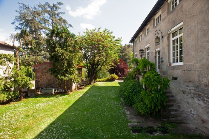 Façade principale en pierre et jardin verdoyant
